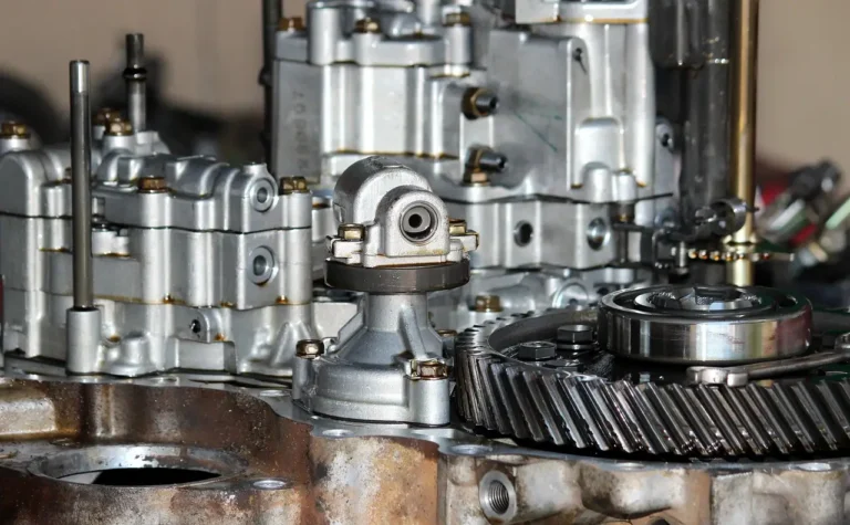 Mechanic inspecting a car drivetrain on a lift in a repair shop