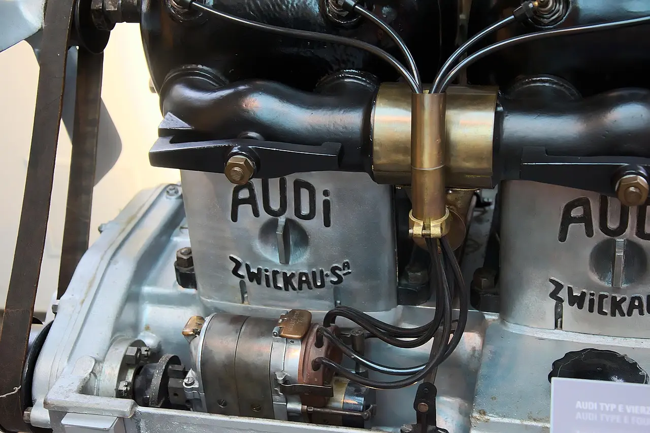 Mechanic and car owner beside an open hood with a removed engine in a repair shop