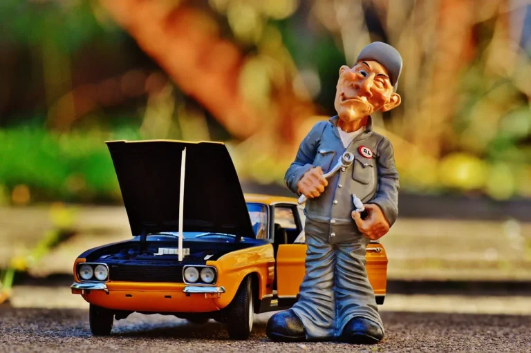 Mechanic and car owner reviewing a car engine replacement estimate beside a sedan with the hood open