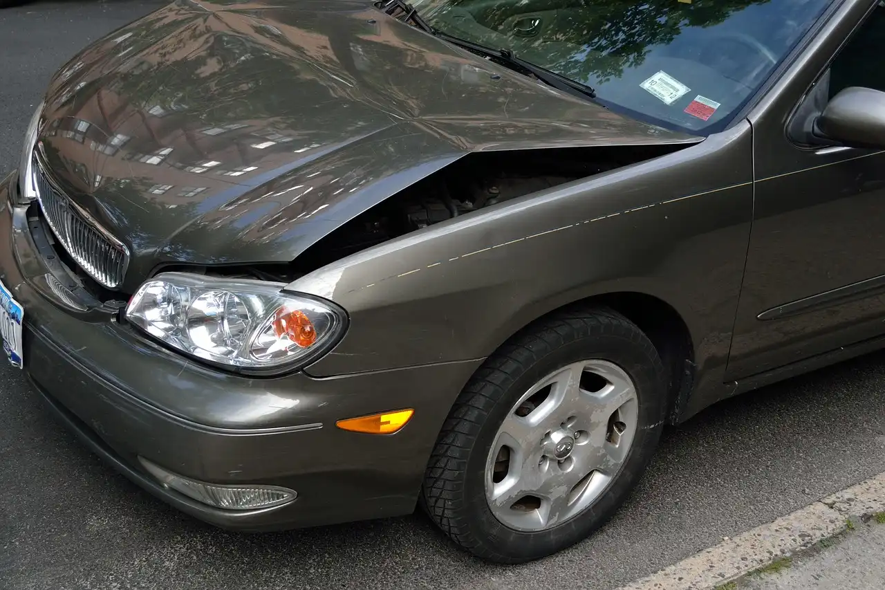 A car inspector examines a sedan in a dealership lot, showing accident clues on a vehicle with a clean title.