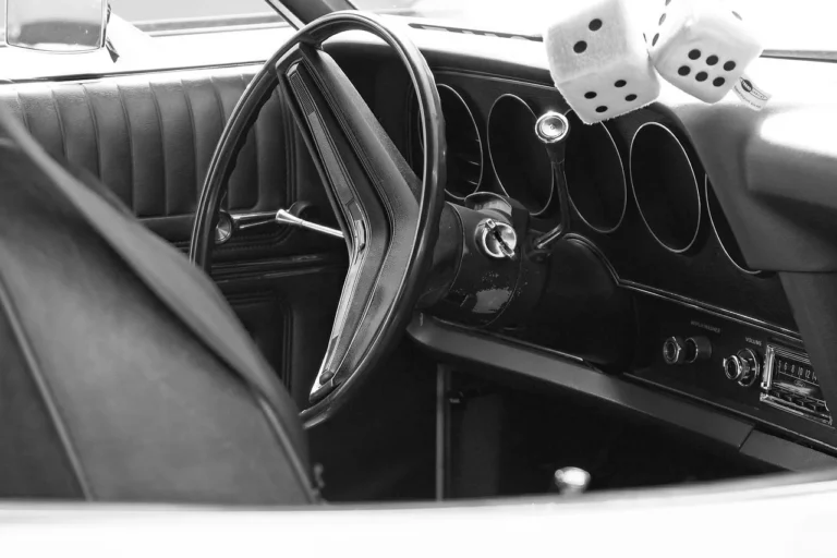 A compact car with a driver organizing daily essentials on the front seat in morning light