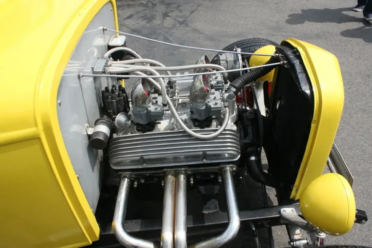 Car owner and mechanic reviewing maintenance for a sedan in a sunlit repair bay