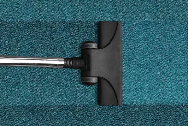 Car vacuum and handheld vacuum beside a car seat as someone cleans the interior in daylight