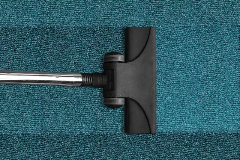 Car vacuum and handheld vacuum beside a car seat as someone cleans the interior in daylight