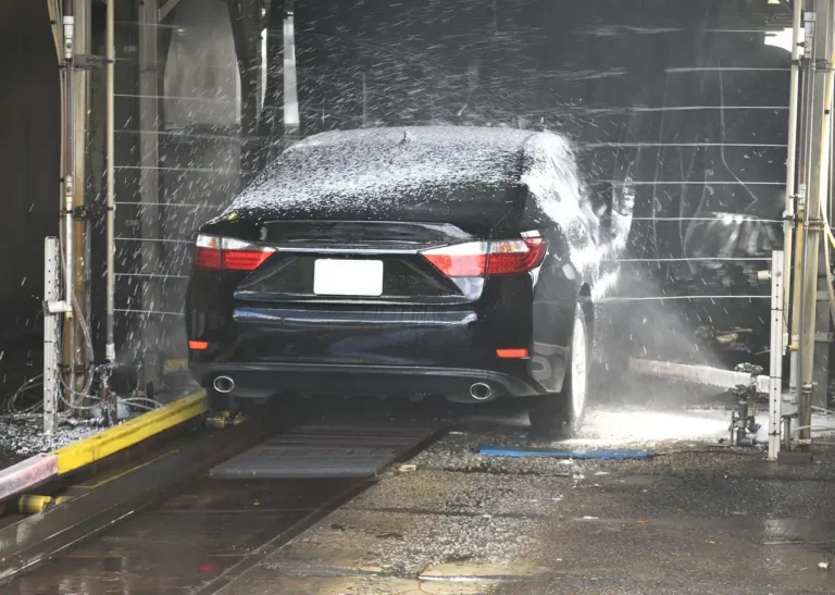Detailer washing a beaded sedan in morning light with bucket and mitt, showing Chemical Guys Mr. Pink Car Wash Soap use