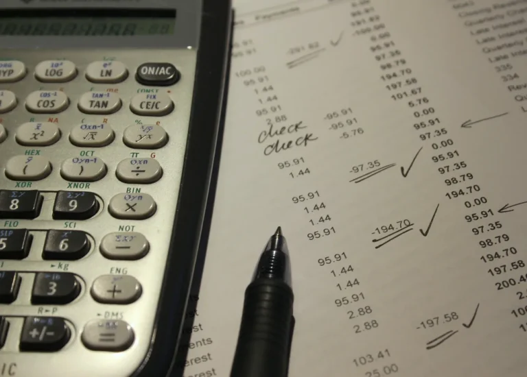 Self-employed contractor reviewing car service receipts beside a work van and mileage log