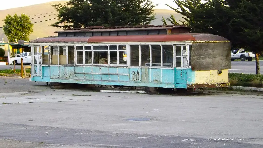 American roadside diner parking lot with drivers carrying burgers, fries, and milkshakes