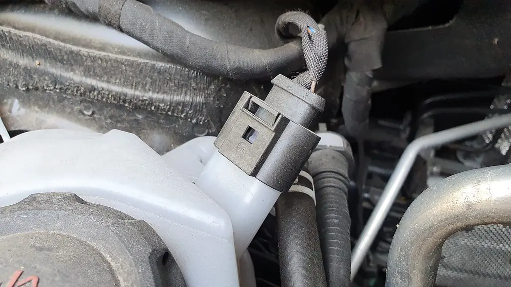 Mechanic checking coolant level in an open car engine bay