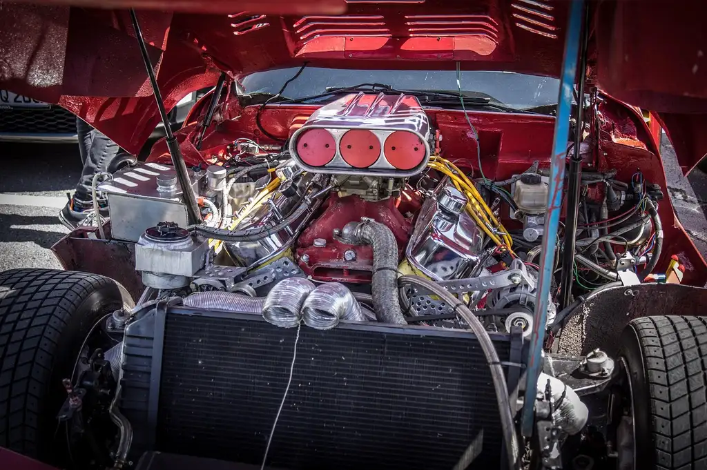 5.3 Chevy engine bay with the driver-side bank visible and a hand pointing to cylinder 5.