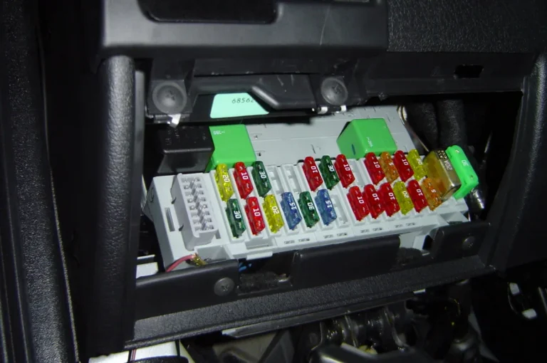 Driver compares a dash cam hardwire kit and cigarette lighter plug beside a parked sedan
