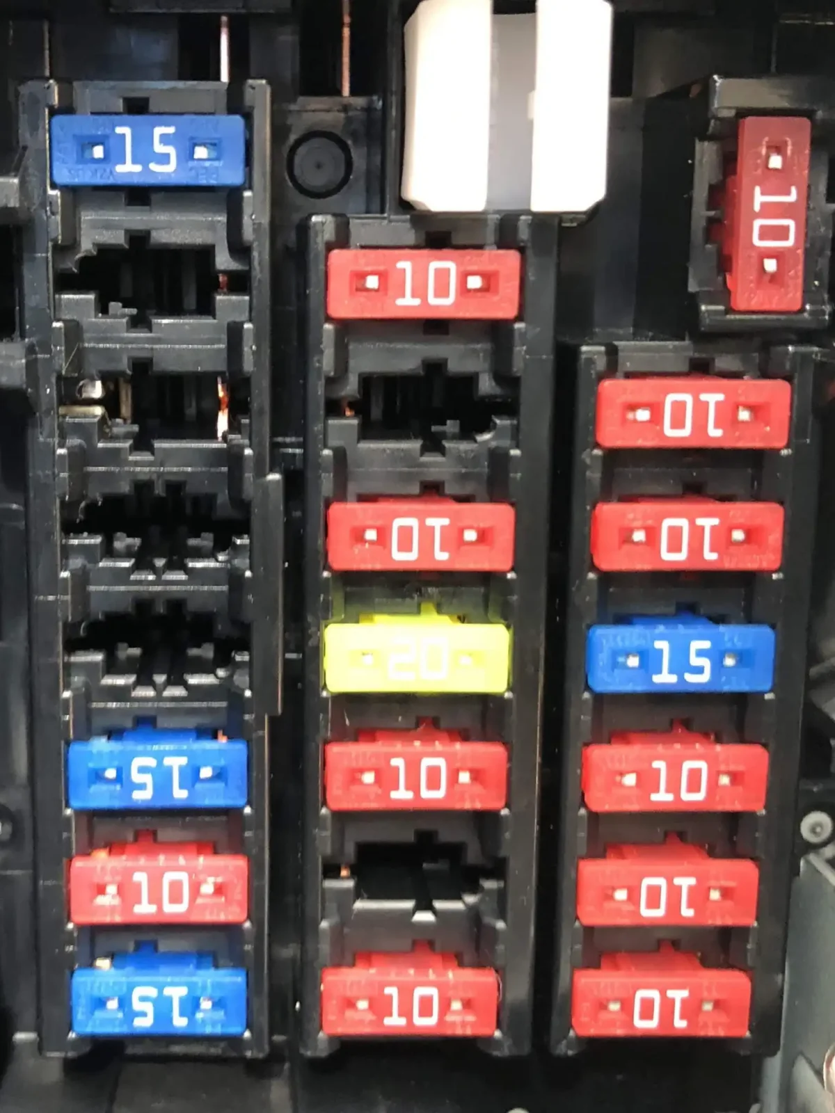 Hands install a dash cam hardwire kit near a car fuse box with exposed wiring