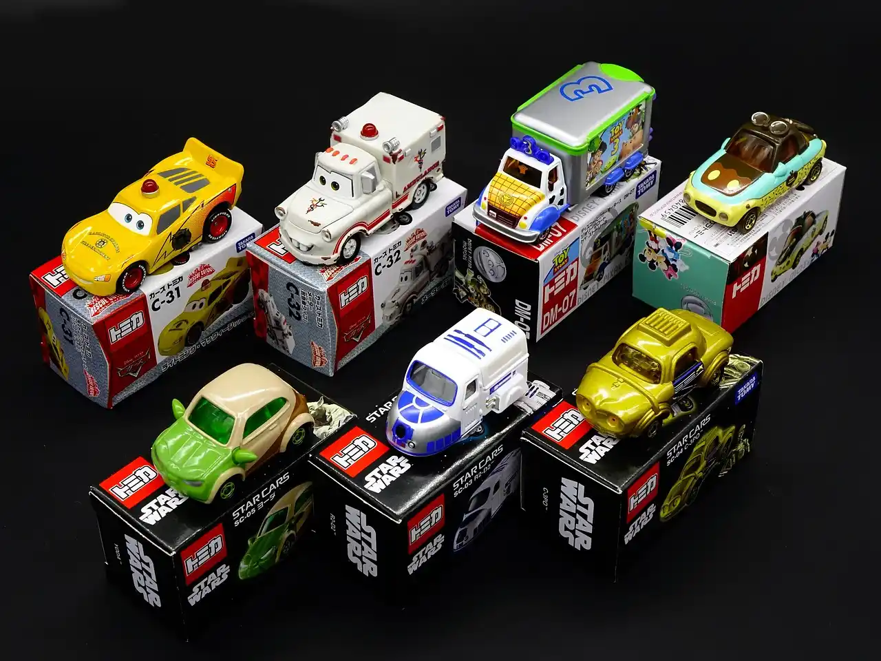 Hot Wheels cars arranged in wall and tabletop display cases in a bright hobby room
