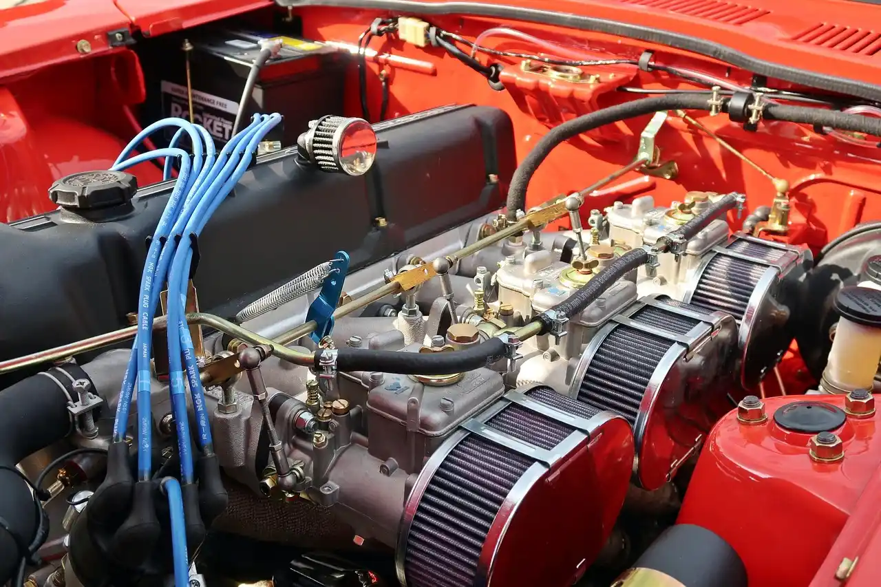 Modern sedan in a service bay with a mechanic and driver checking a diagnostic tablet