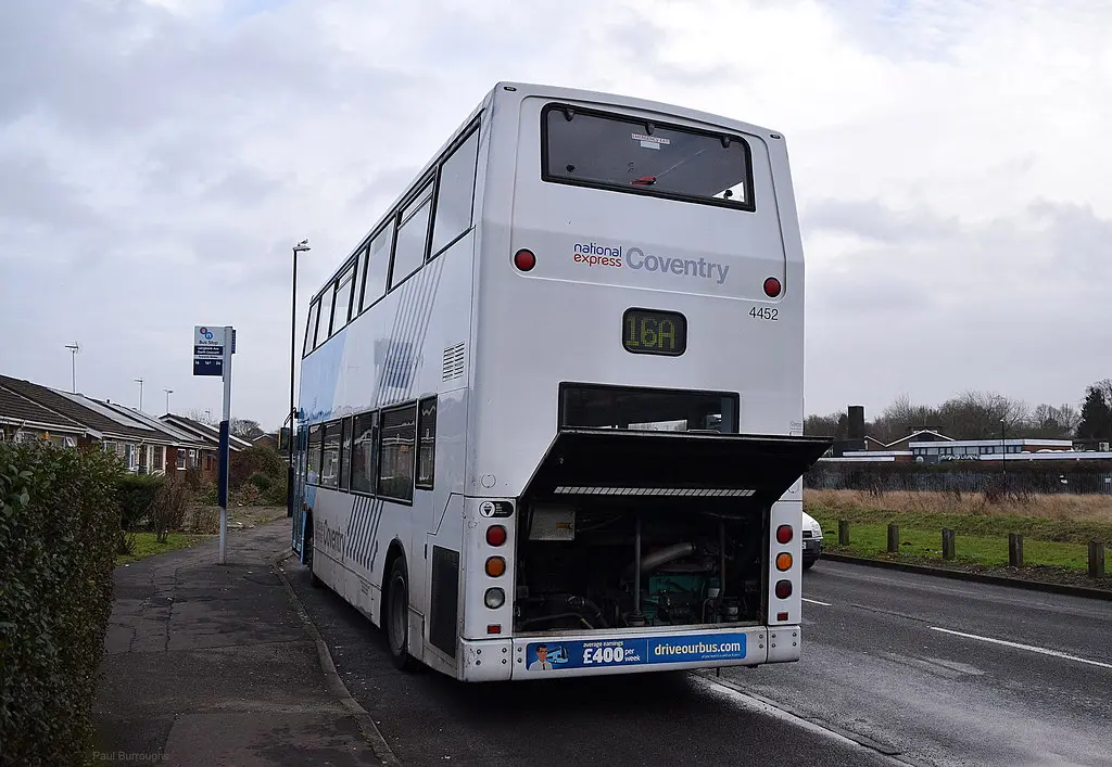 Close-up of a Ford F-150 transmission cooler-line fitting with coolant seepage under inspection
