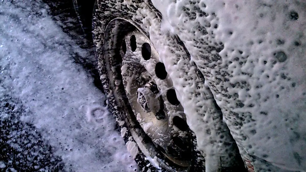 Close-up of foam and a wash mitt cleaning a car panel during a Griot's Garage Foaming Surface Wash