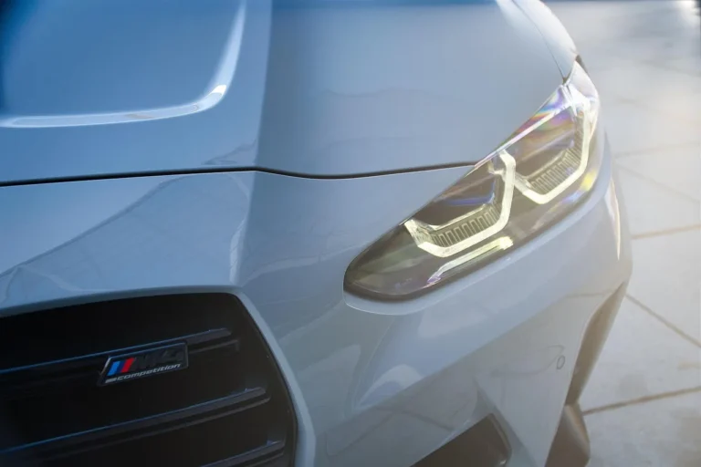 Three cars with halo lights for cars glowing at dusk, with one hood open during inspection.