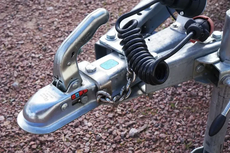 Car owner beside a midsize SUV comparing a tow hitch receiver with a bike rack in natural light.