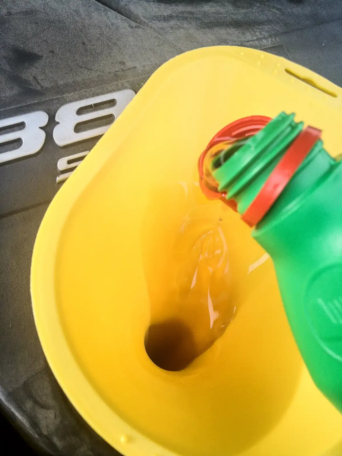 Synthetic motor oil being poured into a Honda Civic engine fill opening