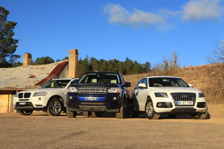 Honda Passport and Kia Telluride parked side by side on a scenic overlook at sunset
