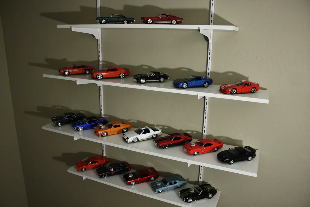 Collector examining a Hot Wheels Car Culture die-cast car on a desk with packaging nearby