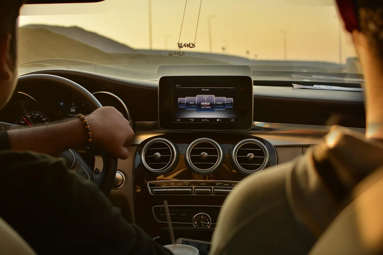 Buyer test-driving a modern sedan with driver-assist indicators visible on the dashboard