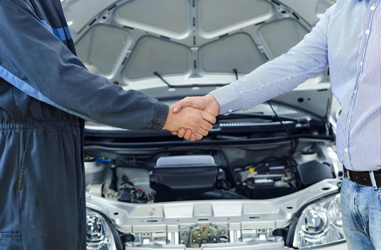 Australian car service quote review beside a car in a workshop