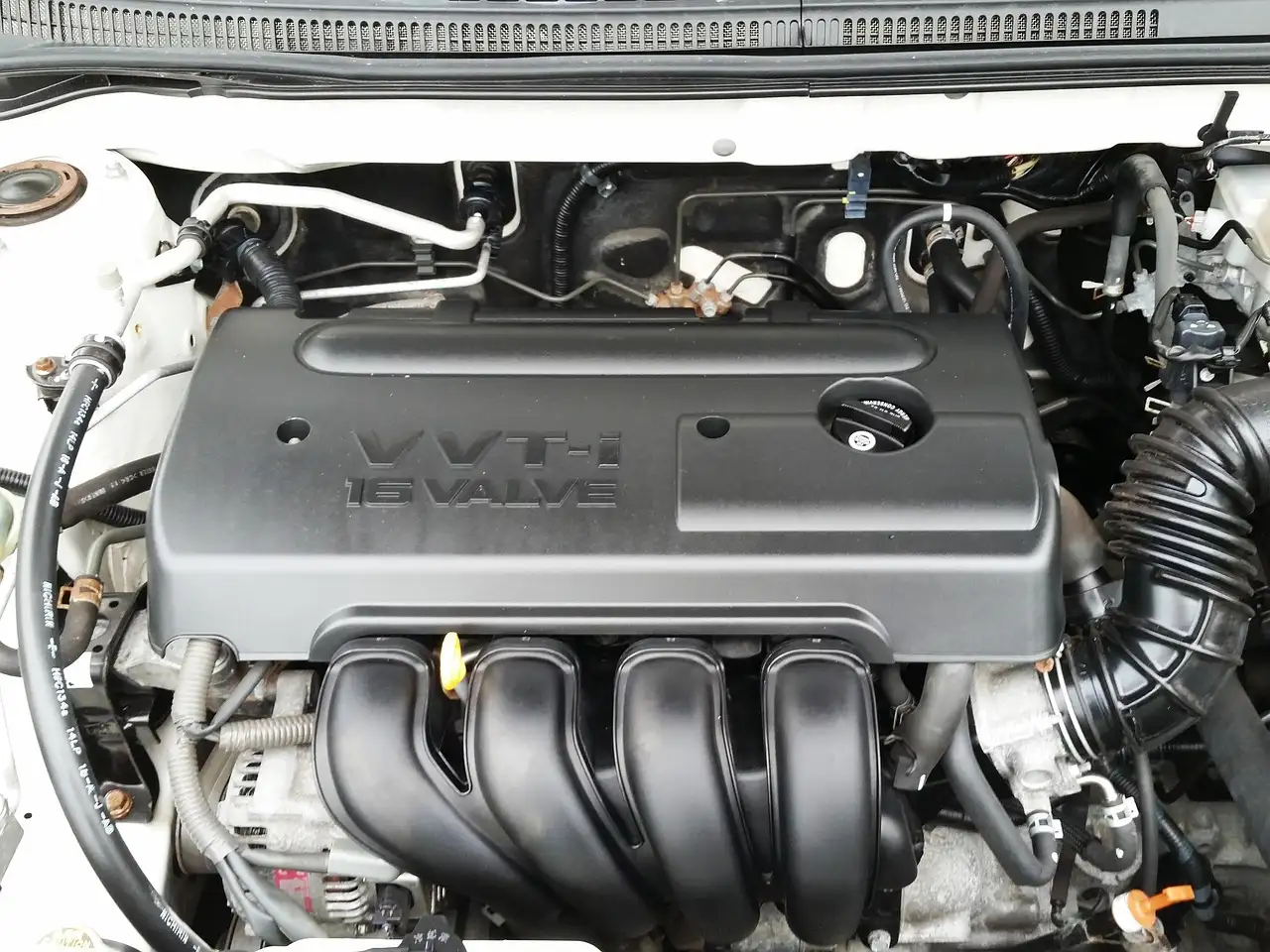Mechanic and customer reviewing a car service estimate beside an open hood