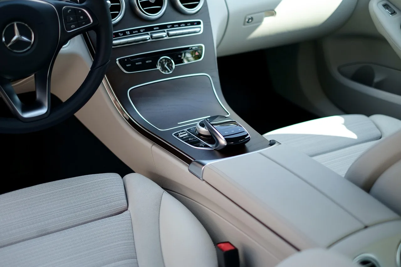 Car detailer cleaning cloth and leather car seats in natural daylight