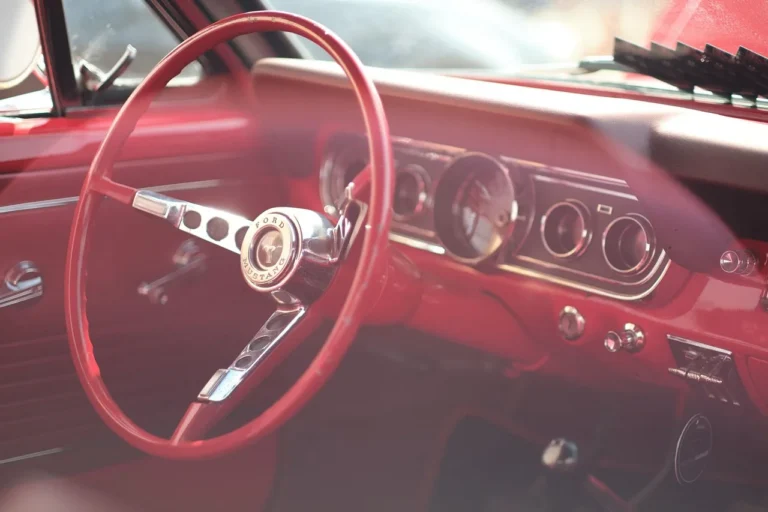 Car buyer and older family member compare a classic coupe with a modern sedan in a driveway.