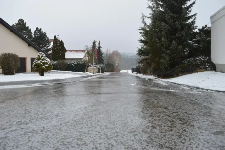 Driver in a sedan gently correcting a slide on a winter road with black ice