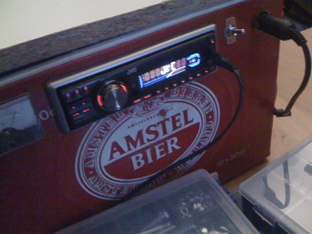 Close-up of a BMW battery terminal being tested with a multimeter and scan tool