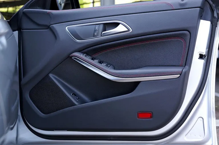 Car leather seat with visible cracks and a small tear being inspected in a sunlit interior