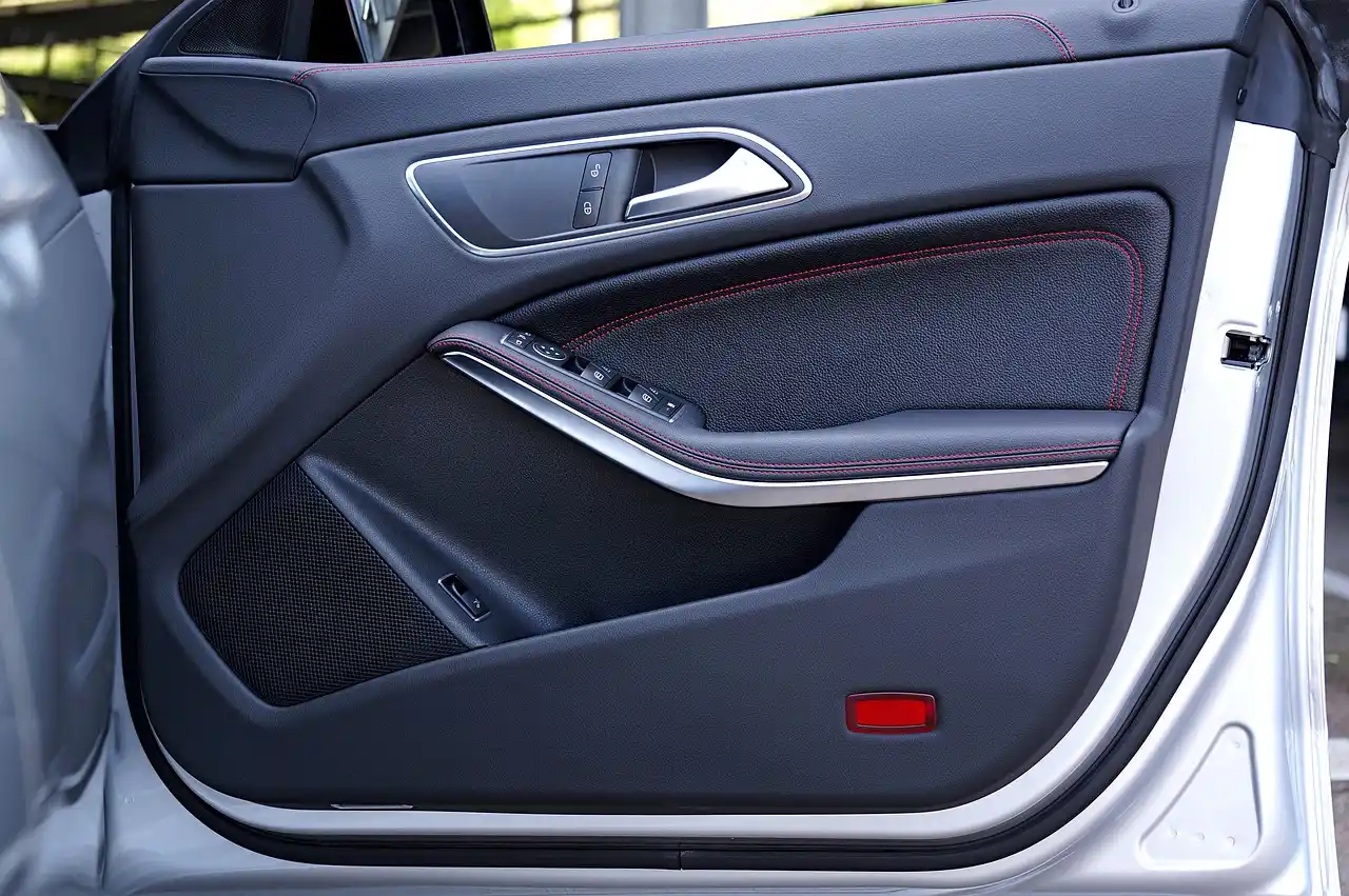 Car leather seat with visible cracks and a small tear being inspected in a sunlit interior