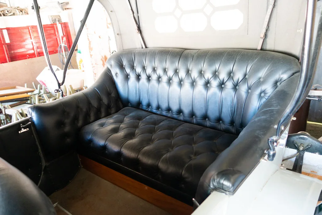 Hands cleaning a car leather seat with a microfiber cloth and leather cleaner