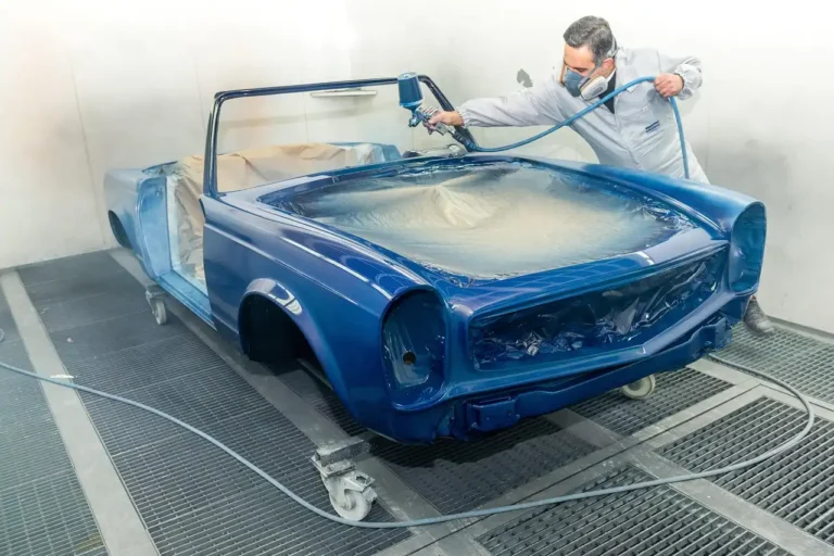 Austin driver reviews an auto repair estimate with a mechanic beside a car in a shop.