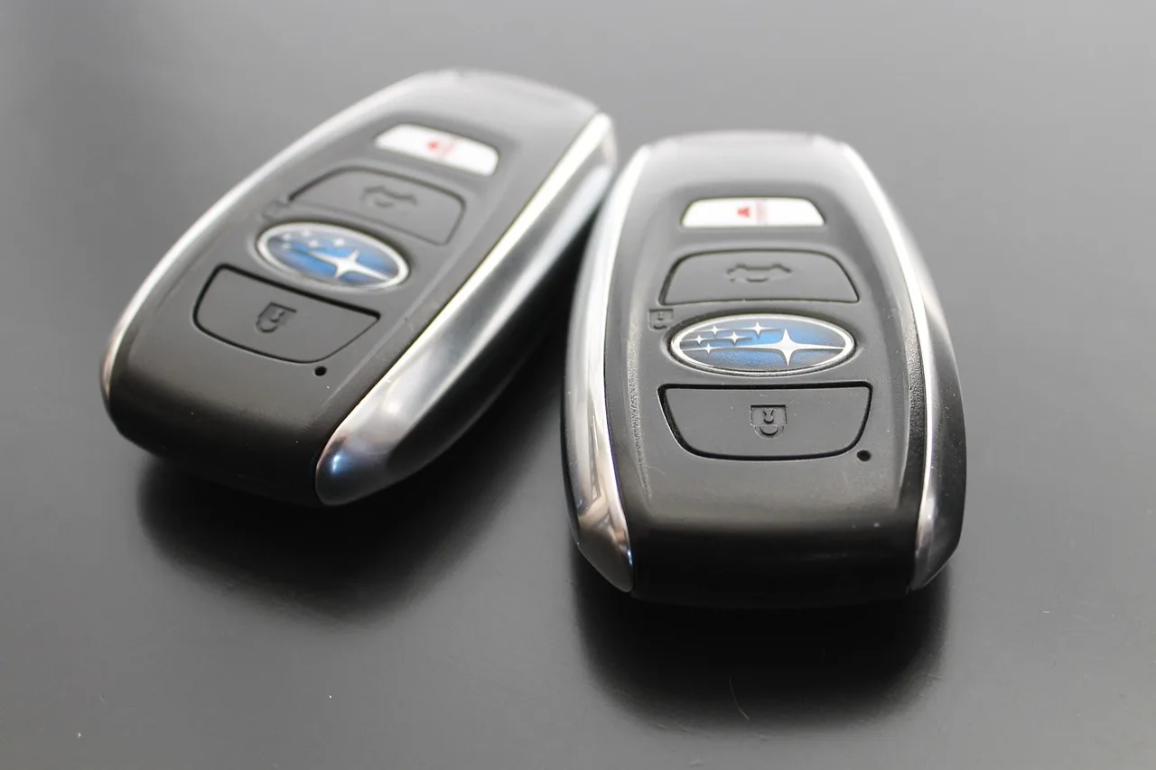 Driver holding a key fob beside a sedan, showing everyday keyless entry convenience