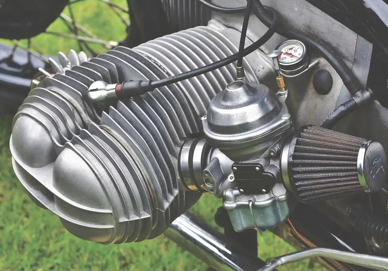 Mechanic checking a carbureted LS engine on an engine stand in a garage