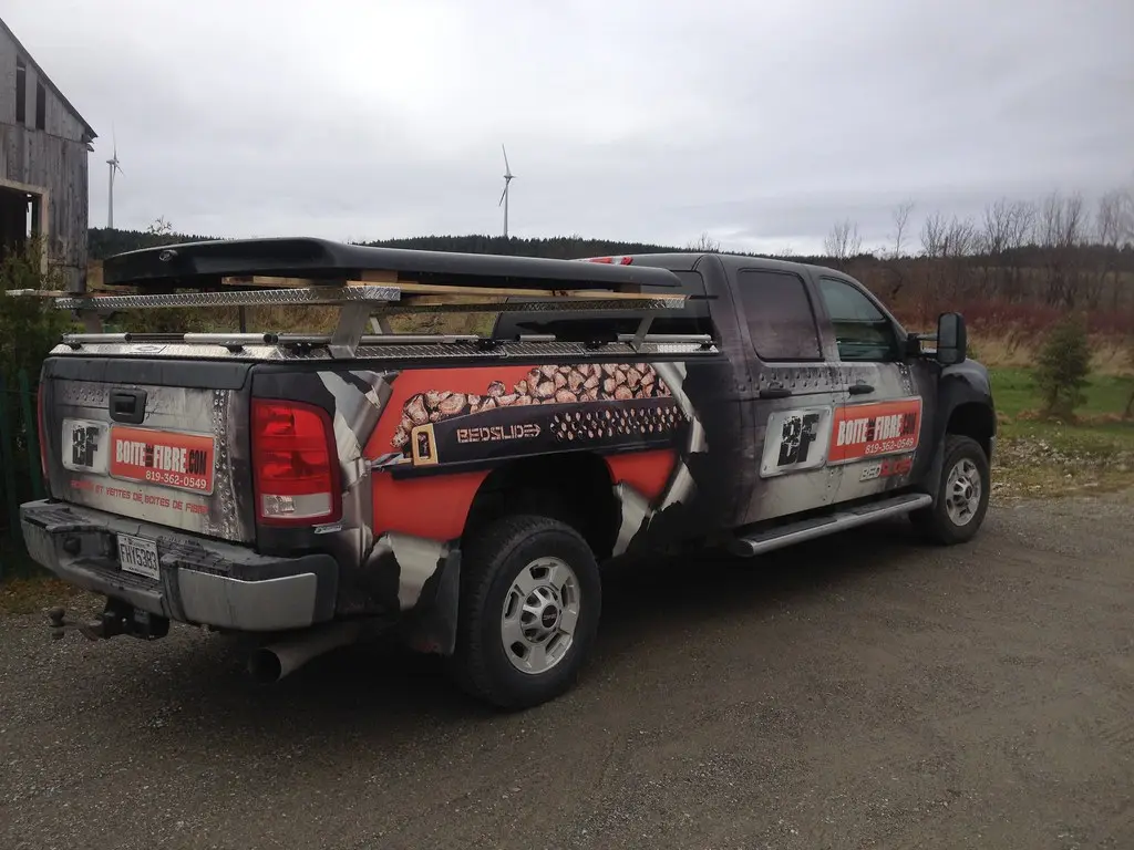 Honda Ridgeline parked with tonneau cover options beside the open truck bed in daylight