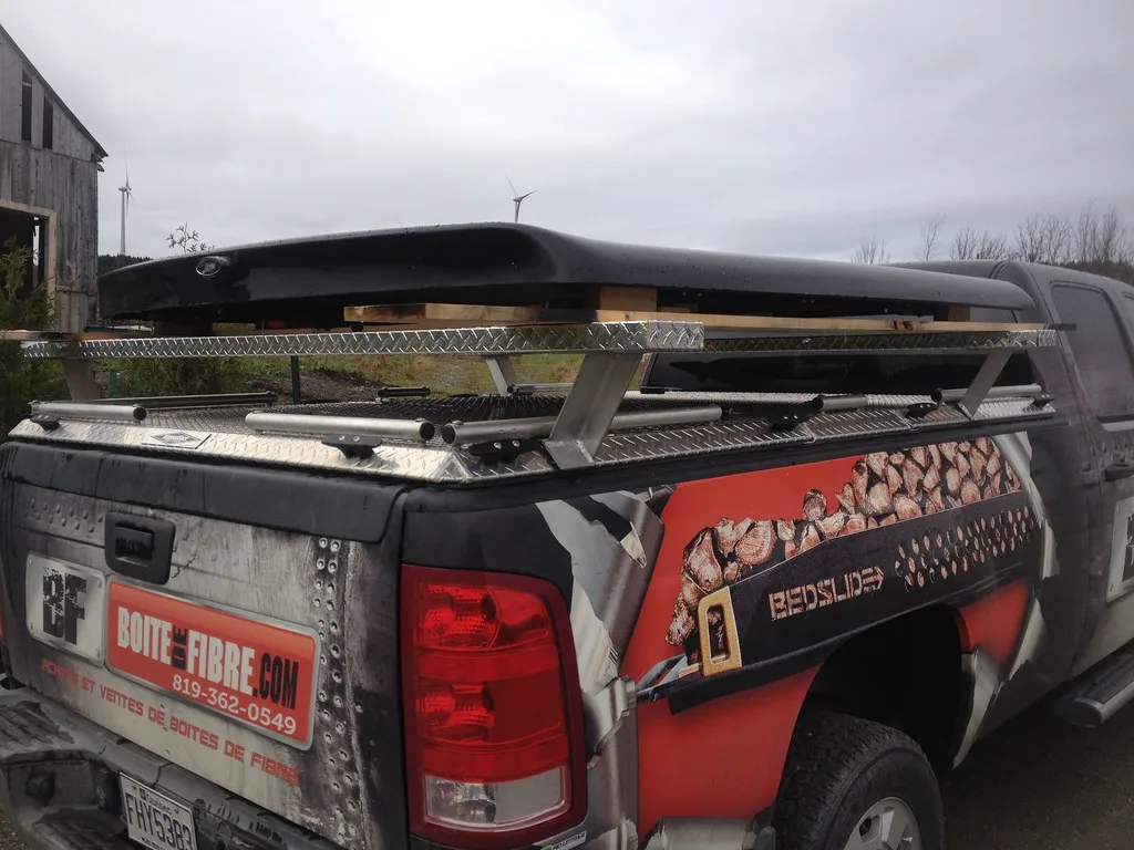 Hands fastening a Honda Ridgeline tonneau cover clamp on the truck bed rail