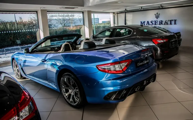 Customer and dealer finance manager review a cashier’s check and car keys at a showroom desk