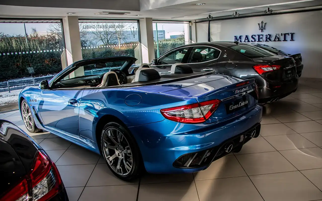 Customer and dealer finance manager review a cashier’s check and car keys at a showroom desk