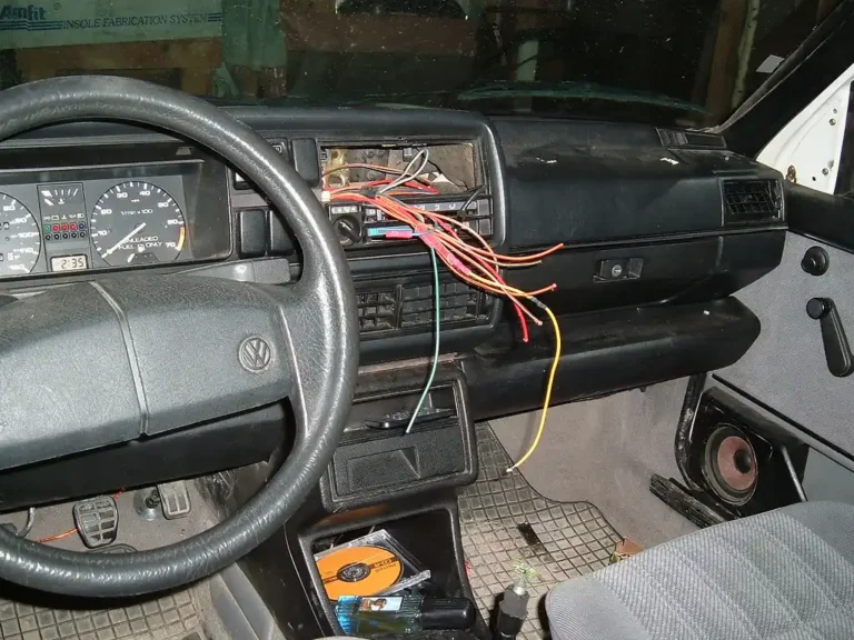 Driver reaching for a Pioneer car stereo touchscreen in a parked car at dusk