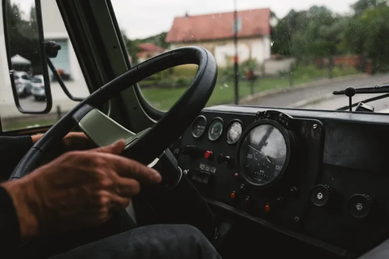 Tense driver gripping a steering wheel in slow traffic at dusk