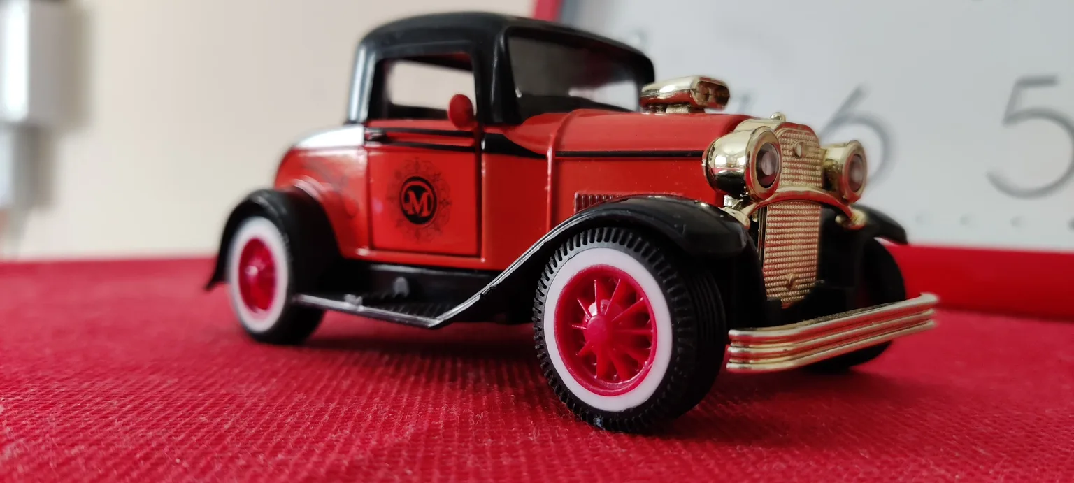 Close-up of a restored Matchbox car being inspected with a loupe and caliper.