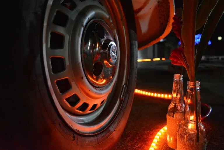 Mechanic installing rim lights on a sedan wheel in natural light
