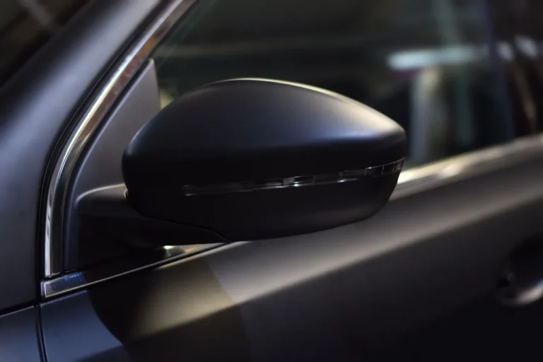 South Carolina driver checking a sedan window tint meter beside a parked car in daylight