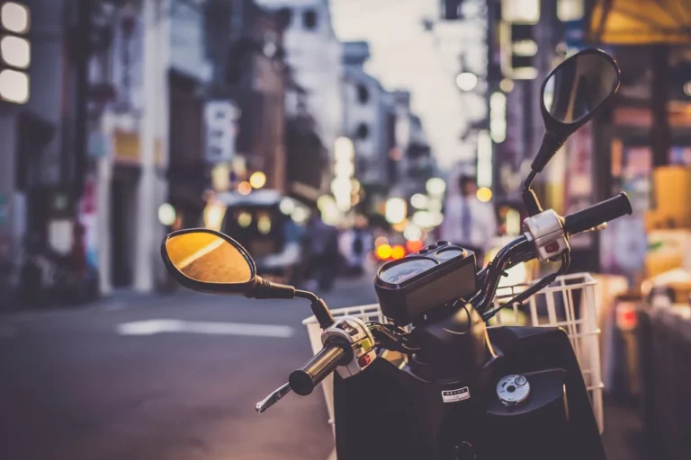 Honda Ruckus scooter in a garage with performance parts laid out beside it