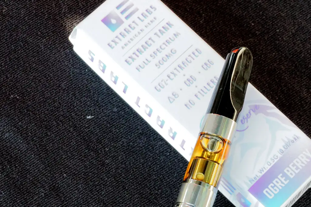 Close-up of a Big Chief cartridge tip being filled with e-liquid beside paper towels