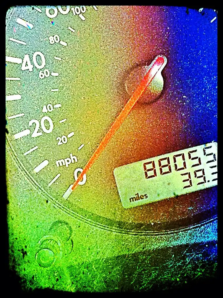 Close-up of a Chevy Equinox dash with a hand using a diagnostic scanner near the OBD port