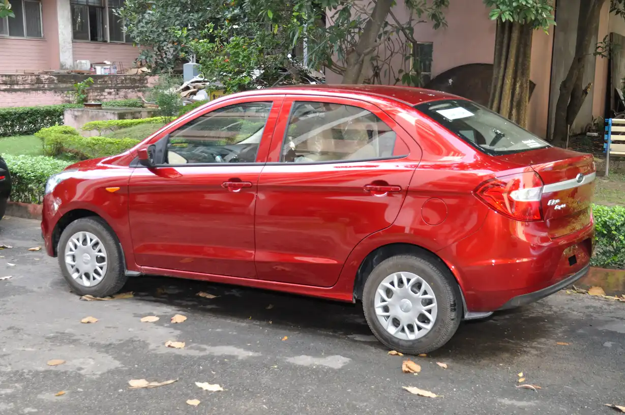 Volkswagen Jetta parked on a suburban street with a person standing beside it in warm natural light